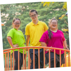 a man and two girls with down syndrome smiling