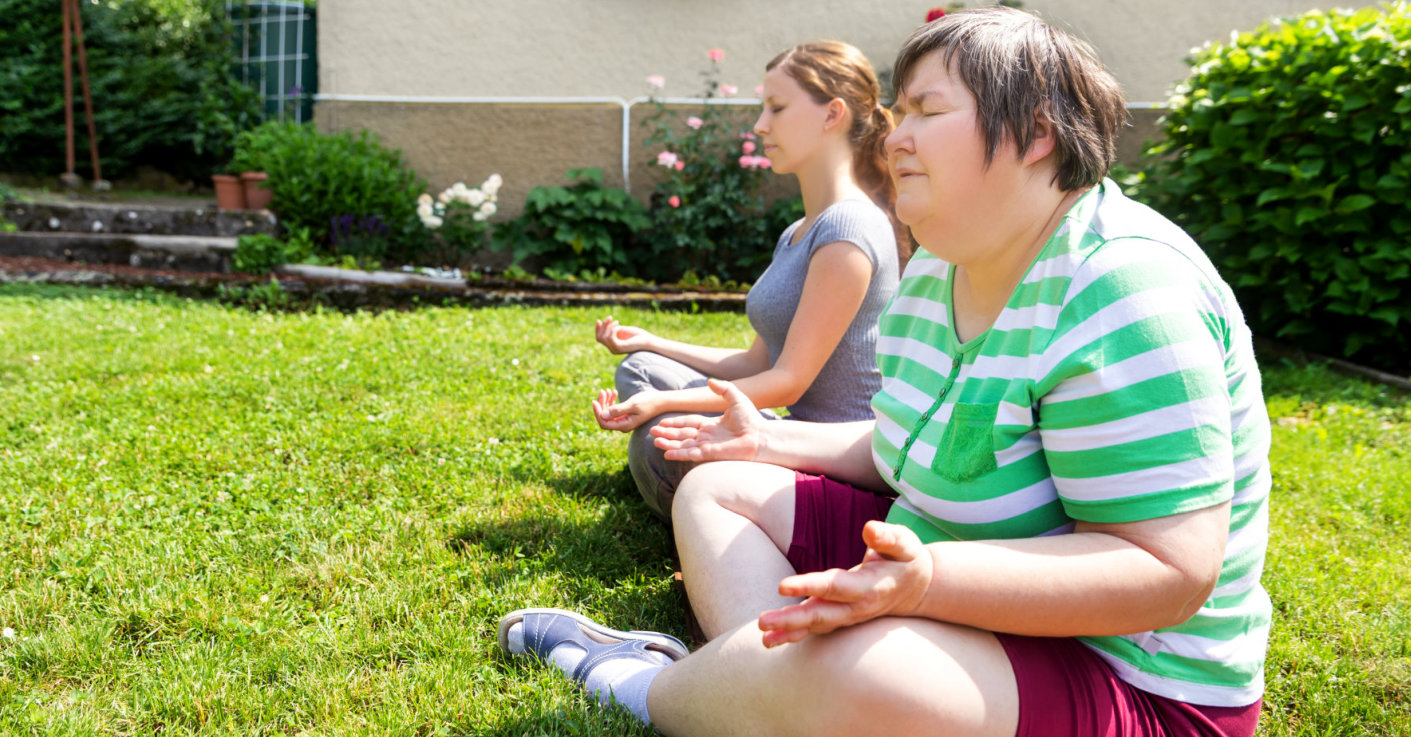 fitness coach and mentally disabled woman doing some relaxation exercises