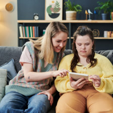 woman and a girl with disability using a tablet